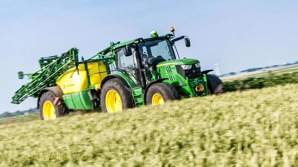 Landbouwer bestuurt John Deere zelfrijdende veldspuit