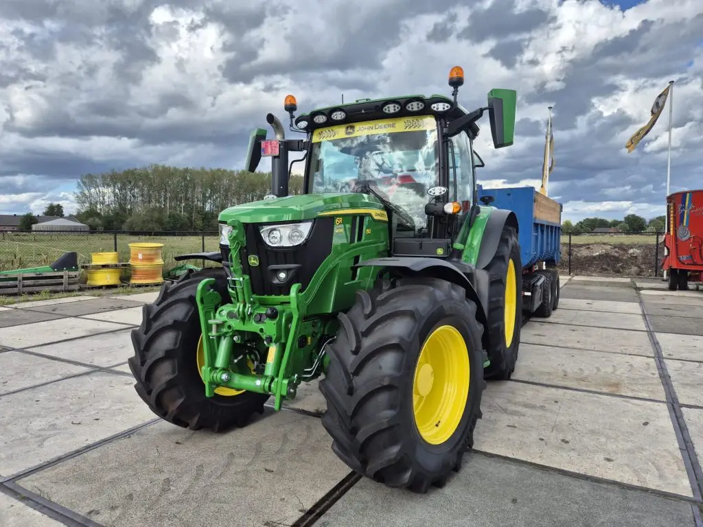 Monteur onderhoudt John Deere trekker bij klant op locatie